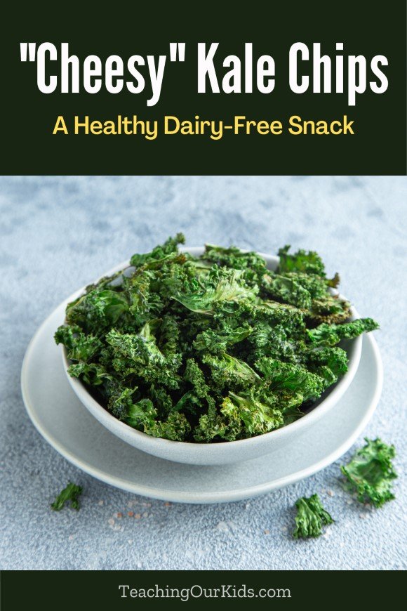 Kale chips in a white bowl with text above saying, "Cheesy kale chips - a healthy dairy-free snack"